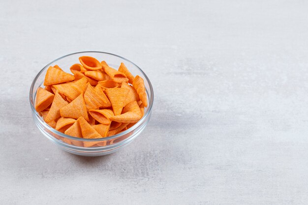 Tasty crunchy chips in glass bowl.