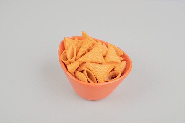 Tasty crunchy chips in orange bowl