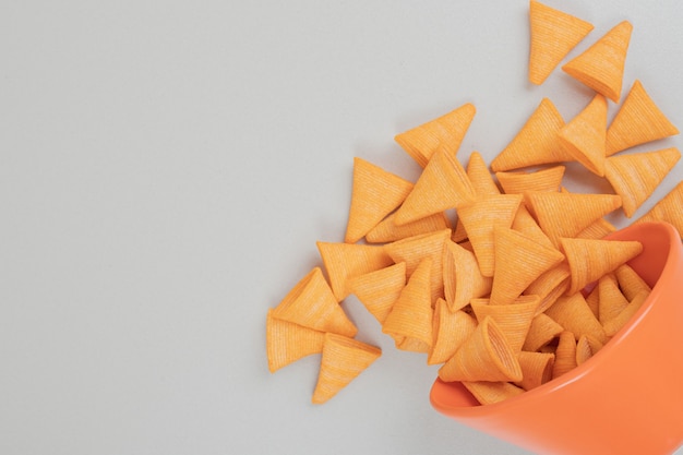 Tasty crunchy chips in orange bowl