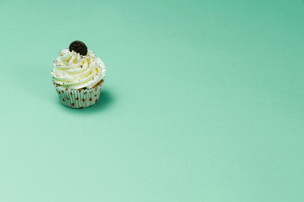 Tasty cupcake on green surface