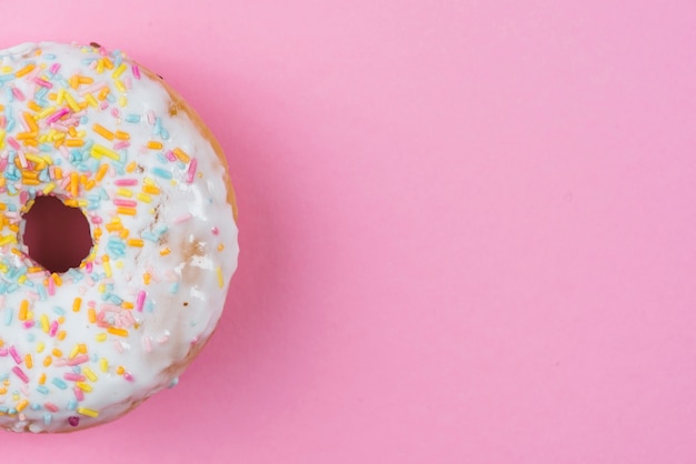 Tasty doughnut with white coating and sprinkles