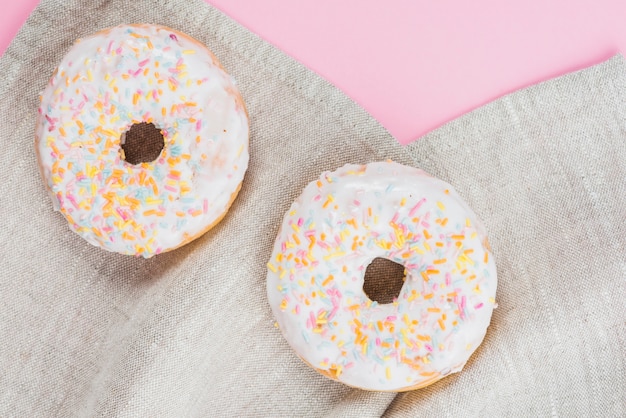 Tasty doughnuts laying on gray fabric