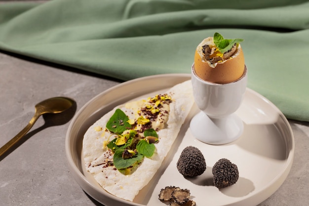 Free photo tasty egg with truffles and pita high angle