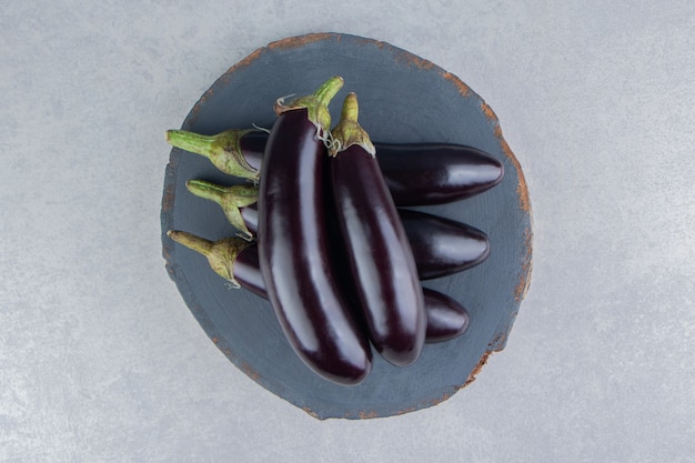 Free photo tasty eggplants on a board on the white surface