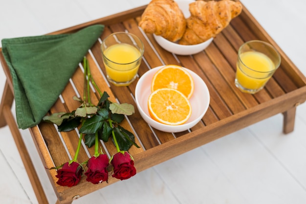 Tasty food and flowers on breakfast table