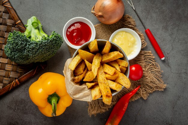 Tasty french fries on on dark background