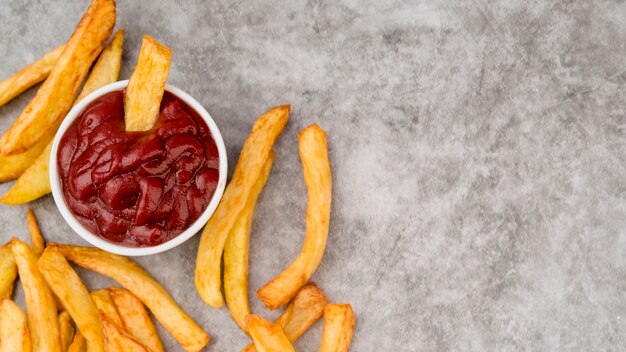 Tasty french fries spread on grey table