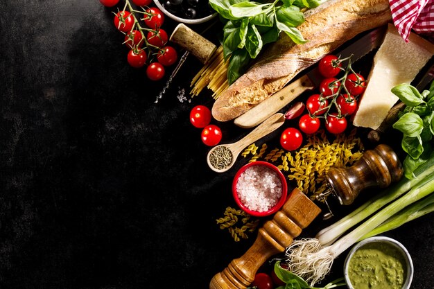 Tasty fresh appetizing italian food ingredients on dark background. 