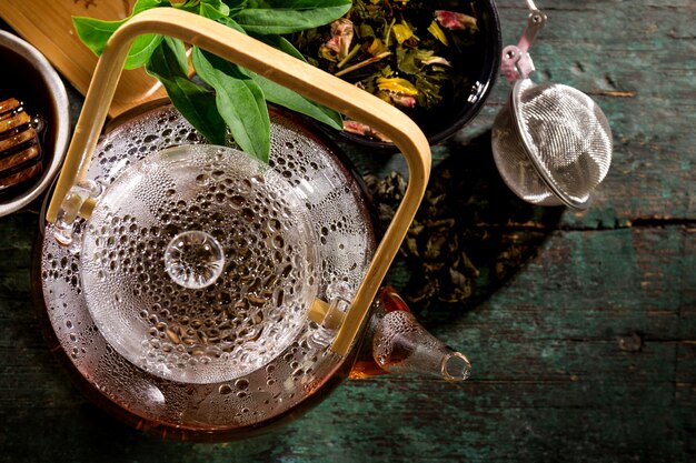 Вкусный свежий зеленый чай в стеклянной чайной церемонии на старом деревенском столе