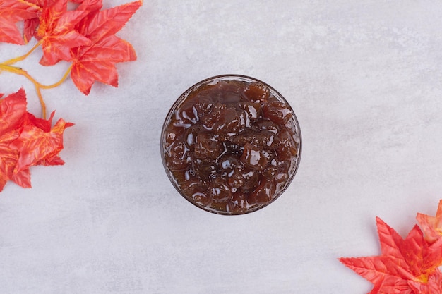 Marmellata gustosa e fresca in lastra di vetro sul tavolo bianco.