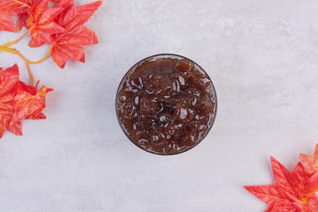 Tasty, fresh jam in glass plate on white table.