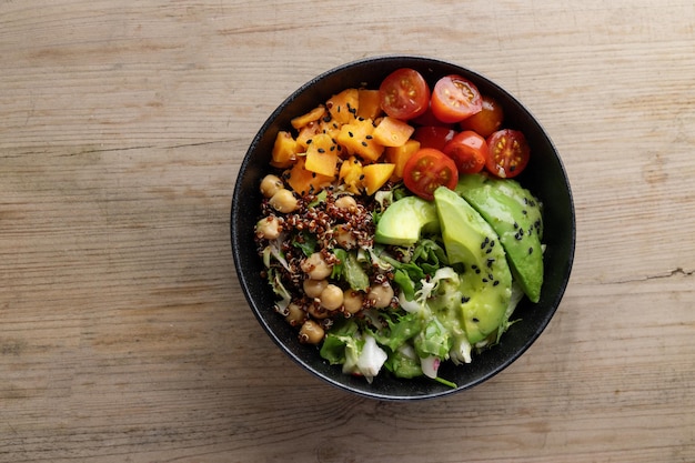 Tasty fresh poke bowl with avocado quinoa and vegetables Top View