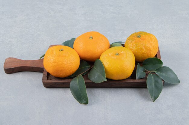 Tasty fresh tangerines on wooden board. 