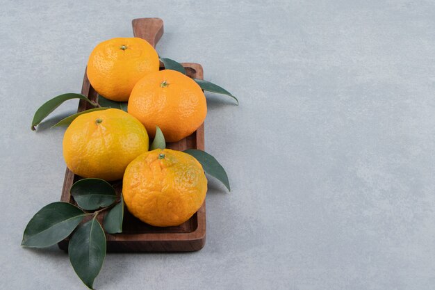 Tasty fresh tangerines on wooden board. 