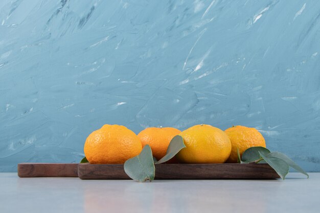 Tasty fresh tangerines on wooden board