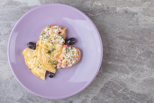 Tasty fried eggs on purple plate.