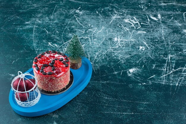 Tasty fruit cake with Christmas balls and Christmas tree. High quality photo