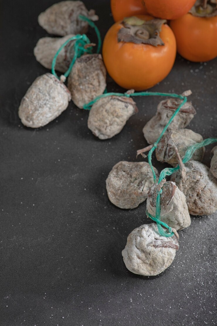 Бесплатный Фотография вкусная хурма фую и сушеная хурма на черной поверхности