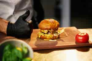 Бесплатное фото Вкусный грилированный говяжий бургер на доске для резки