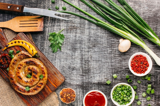 Free photo tasty grilled sausages and fresh vegetable on old backdrop