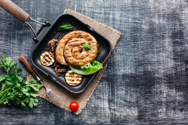 Tasty grilled spiral sausages for meal on gray wooden background