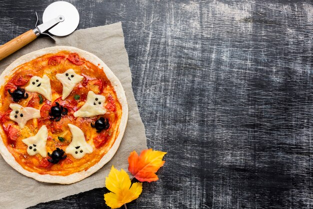 Tasty halloween pizza with autumn leaves