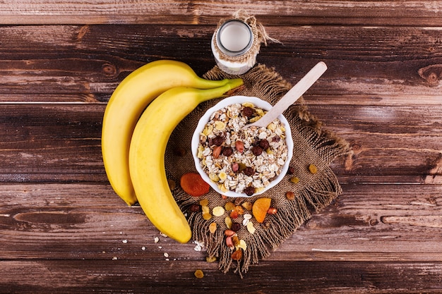 Free photo tasty healthy morning breakfast made of milk and porridge with nuts, apples and bananas