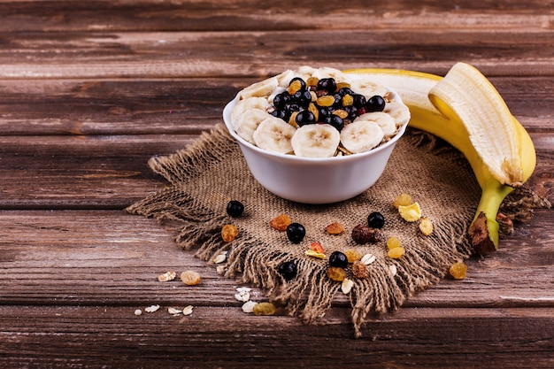 Tasty healthy morning breakfast made of milk and porridge with nuts, bananas and honey