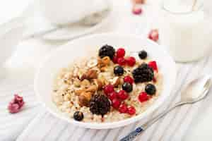 Foto gratuita porridge di farina d'avena gustoso e sano con bacche, semi di lino e noci. colazione salutare. cibo fitness.