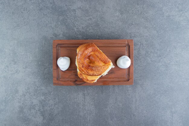 Tasty homemade pastry and cream on wooden board.