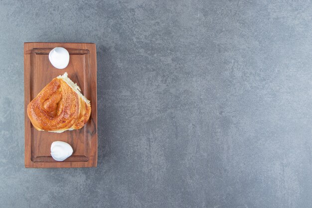 Tasty homemade pastry and cream on wooden board.