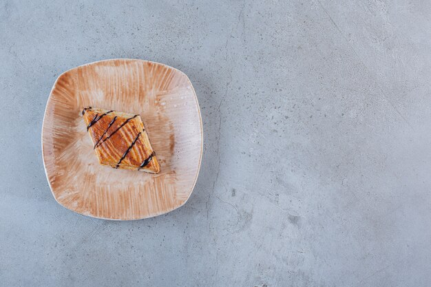 Tasty homemade pastry decorated with chocolate placed on plate.