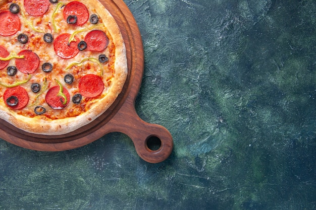 Tasty homemade pizza on wooden board on the right side on isolated dark surface