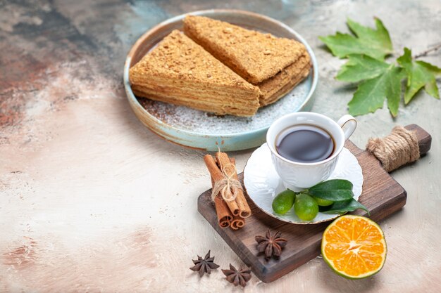tasty honey cake with cup of tea on light