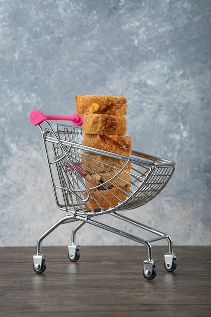 Free photo tasty hot sushi rolls in small trolley on wooden table.