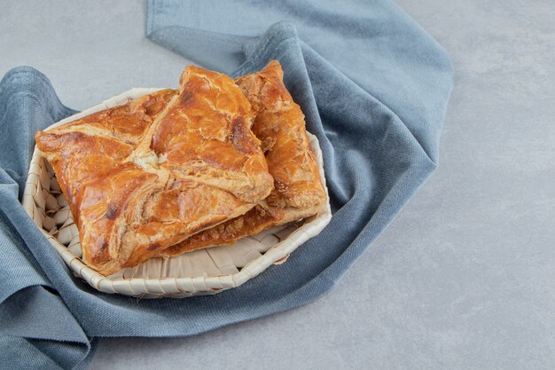 Tasty khachapuri pastries in wooden basket. 