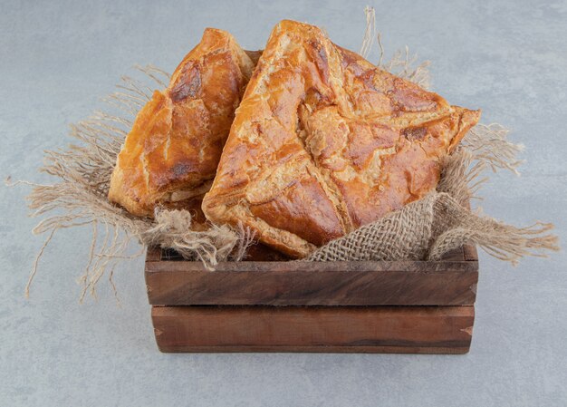 Tasty khachapuri pastries in wooden box. 