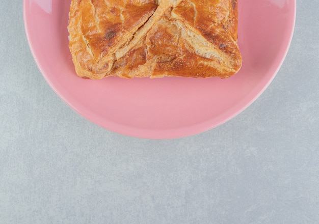 Tasty khachapuri pastry on pink plate