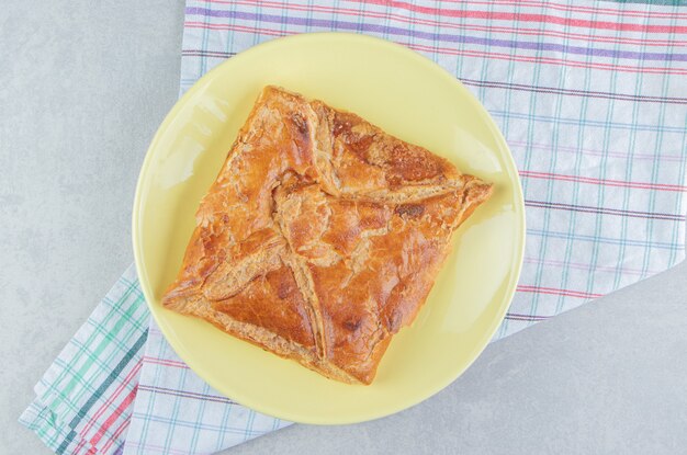 Tasty khachapuri pastry on yellow plate. 