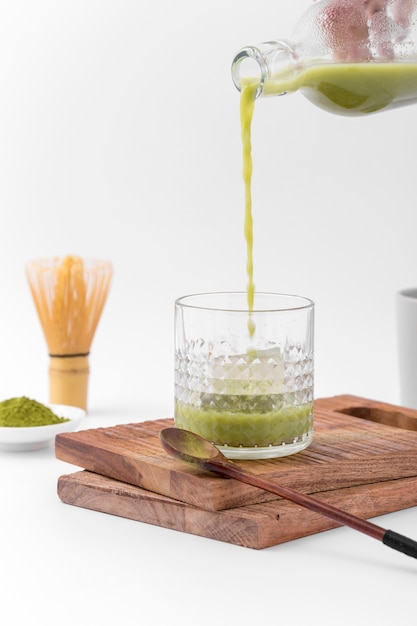 Tasty matcha tea pouring into glass