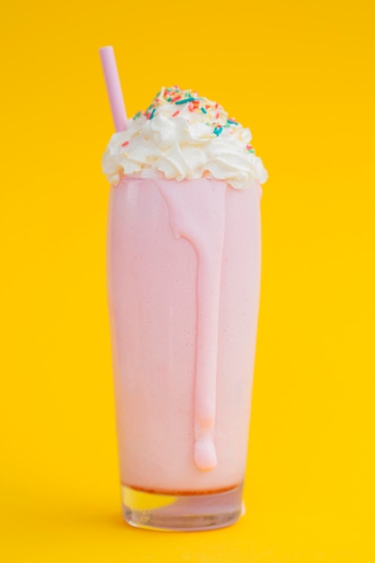 Tasty milkshake on yellow background