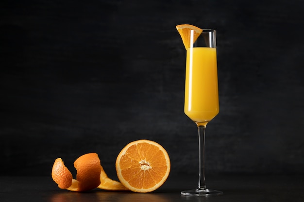 Вкусный коктейльный бокал мимозы с дольками апельсина