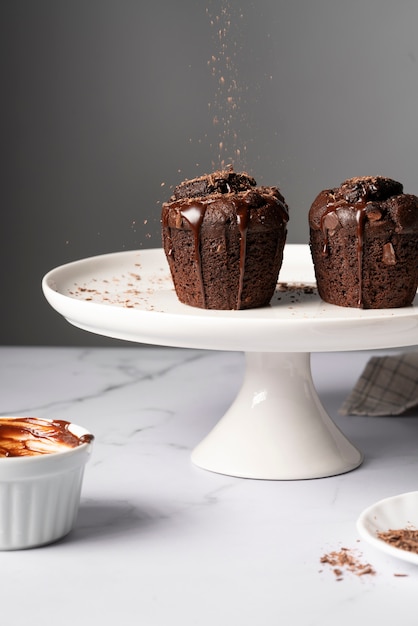 Tasty muffins with chocolate topping on stand