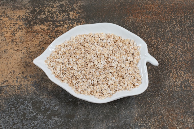 Tasty oat flakes on leaf shaped plate. 