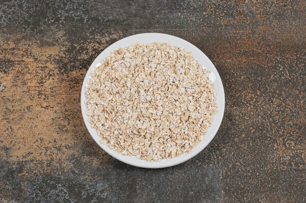 Tasty oat flakes on white plate. 