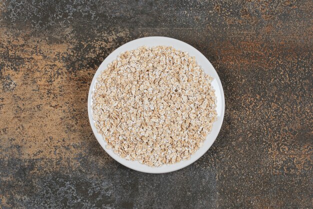 Tasty oat flakes on white plate. 