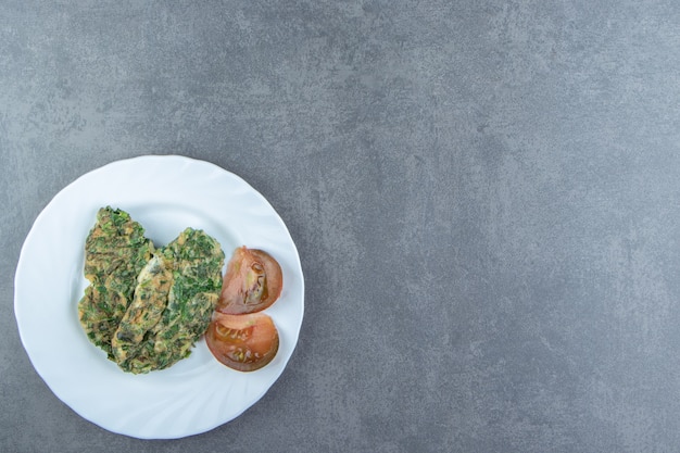 Gustosa frittata con verdure sul piatto bianco.