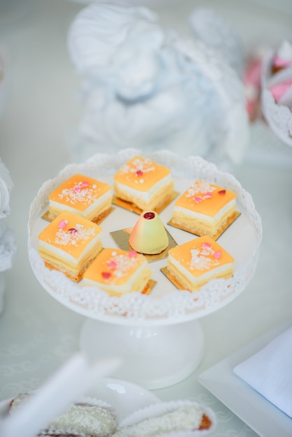 Tasty orange cakes served on round white dish 