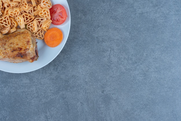 Pasta saporita con pezzi di carne sul piatto bianco.