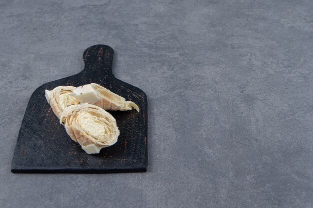 Tasty pastries with custard on black board. 